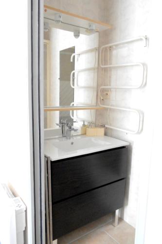 une salle de bain avec un lavabo et un miroir dans l'établissement Hâvre de paix en bord de mer, à Lannion