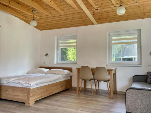 a bedroom with a bed and a table and chairs at Przystań Ogrodowa Mikołajki in Mikołajki