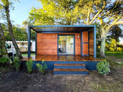 une petite cabane en bois avec une terrasse en bois dans l'établissement Petits Chalets D'Herm, à Herm
