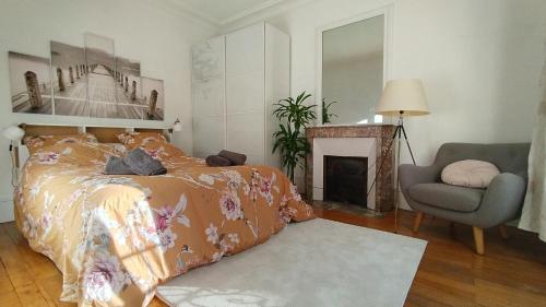 a bedroom with a bed and a chair and a fireplace at La Bulle du bois in Clamart