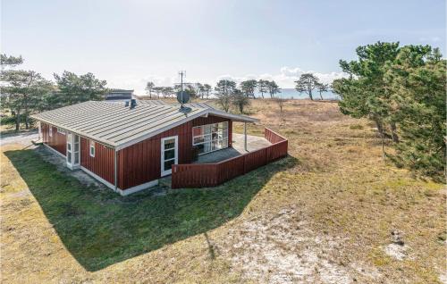una pequeña casa roja en un campo con árboles en Holiday Home Aakirkeby With Fireplace 02, en Vester Sømarken