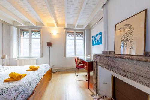 - une chambre avec un lit, une cheminée et un bureau dans l'établissement Appartement de Caractère T5 en Hypercentre, à Toulouse