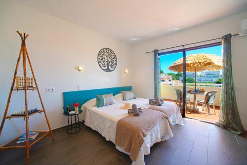 a bedroom with a bed and an umbrella and a table at Sol Brilhante in Albufeira
