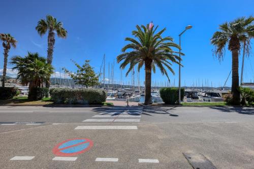 un parking avec des palmiers et une rue dans l'établissement Appartement Osta - Welkeys, à Bandol
