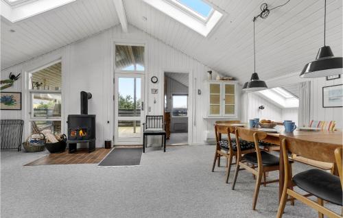 a living room with a table and a fireplace at Amazing Home In Thisted With Sauna in Torsted