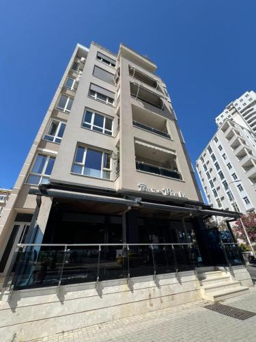 a tall building with a restaurant in front of it at Gold Vollga House Durres in Durrës