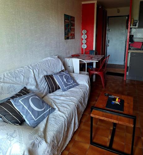 un salon avec un canapé et une table dans l'établissement Studio Asphodèles bord de mer, au Cap d'Agde