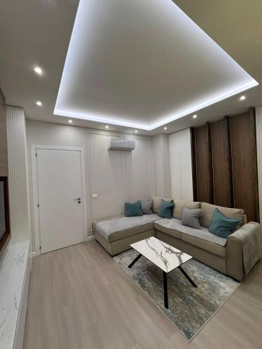 a living room with a couch and a table at Gold Vollga House Durres in Durrës