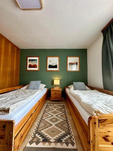 two beds in a room with green walls at Haus Wagner in Bad Kleinkirchheim