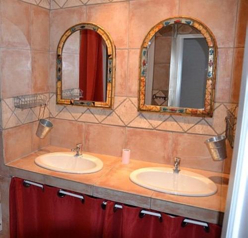 deux lavabos dans une salle de bain avec deux miroirs dans l'établissement Mas La Provence, à Rustrel