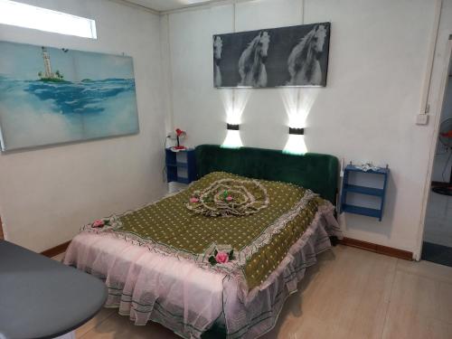 a bedroom with a bed with a green head board at Open Air Café & Apartments in Port Louis