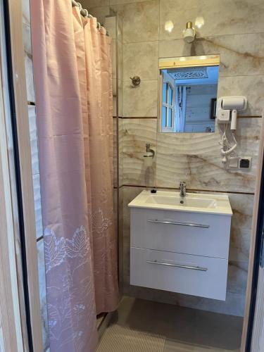 a bathroom with a sink and a mirror and a shower at Pokoje u Magdusi przy termach in Witów