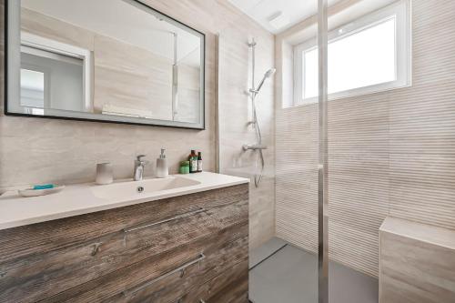 une salle de bain avec un lavabo et une douche avec un miroir dans l'établissement Maison Familiale 8 Pers Jardin Jacuzzi Gare Parking, à Fontenay-sous-Bois