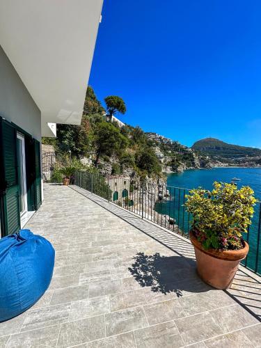 a building with a walkway next to a body of water at Villa Il Carrubo - Amalfi Coast in Vietri sul Mare