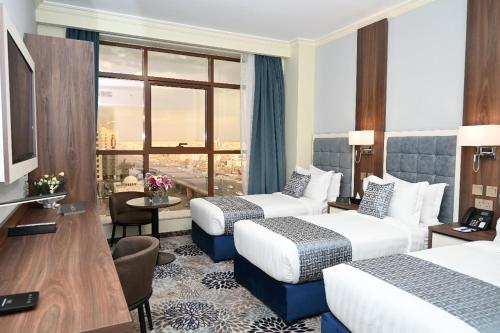 a hotel room with two beds and a window at Castle Hotel in Medina