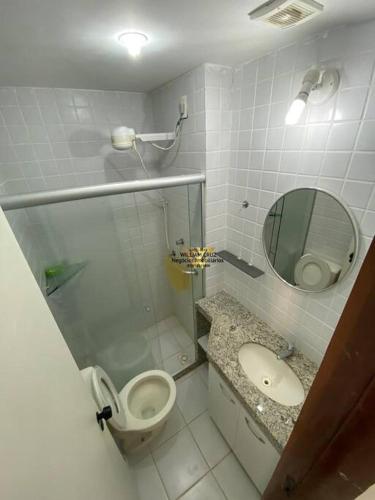 a bathroom with a toilet and a sink and a mirror at Flat Monte Castelo, Gravatá in Bezerros