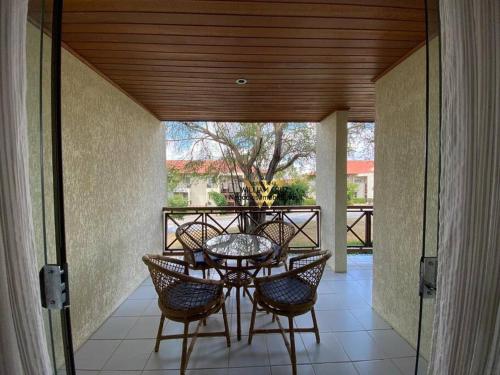 eine Terrasse mit Tisch und Stühlen auf einer Veranda in der Unterkunft Flat Monte Castelo, Gravatá in Bezerros