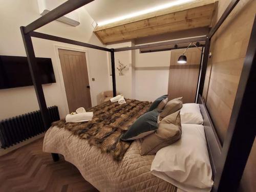 a bedroom with a large bed with pillows on it at Tudor Cottage, Hot Tub, Sleeps 8 in Llandudno