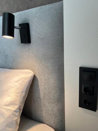 a bedroom with a bed and a wall with a lamp at City Panorama with SAUNA in Tartu