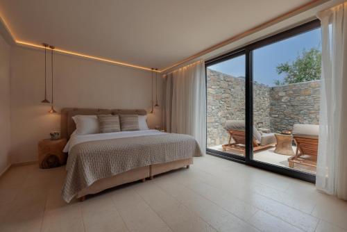 a bedroom with a bed and a large window at Asty Mykonos Hotel & Spa - World of One Hotel Group in Mýkonos City