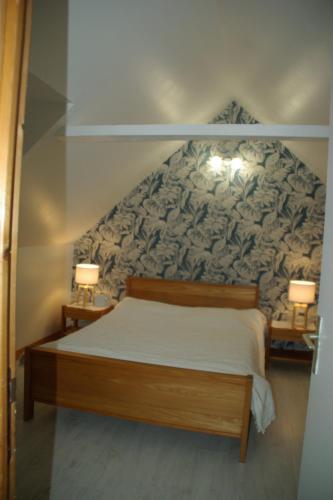 une chambre avec un lit avec deux lampes sur deux tables dans l'établissement Maison au calme en pleine nature à Bourbriac, à Bourbriac