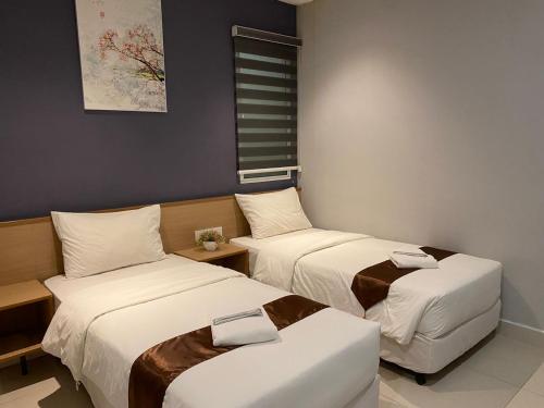 a hotel room with two beds and a couch at MD Boutique Hotel in Kampar