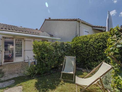 two chairs sitting in the yard of a house at Holiday Home Les Jardins de l'Océan-2 by Interhome in Pontaillac