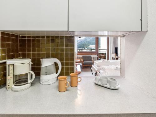 a kitchen with cups and appliances on the counter at Apartment Guardaval - Utoring-1 by Interhome in Davos