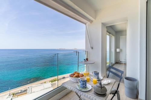 un balcon avec une table et une vue sur l'océan dans l'établissement L'Echappée Marine - Welkeys, à Marseille
