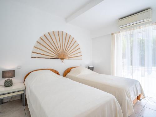 deux lits dans une chambre blanche avec une fenêtre dans l'établissement Apartment Cannes Bay-1 by Interhome, à Cannes