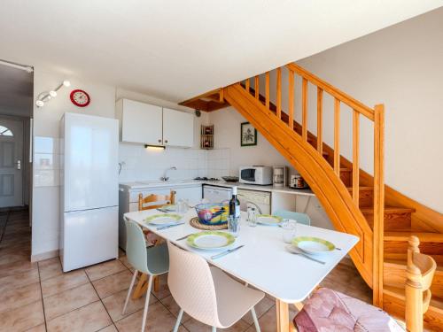 une cuisine et une salle à manger avec une table et un escalier dans l'établissement Apartment Les Exals by Interhome, à Saint Pierre La Mer