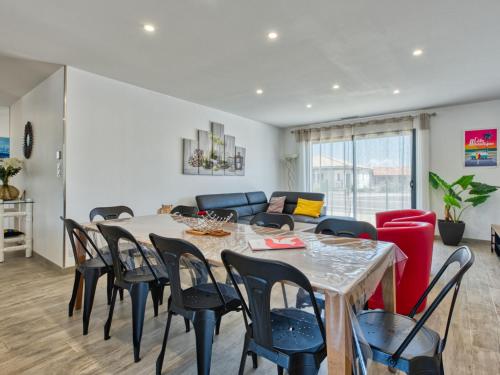 a dining room and living room with a table and chairs at Villa Les Alyzés by Interhome in Vensac
