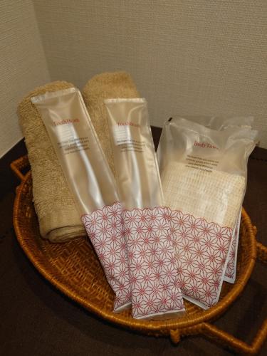 a basket with three packets of soap and towels at ゲストハウス長閑 in Toyooka