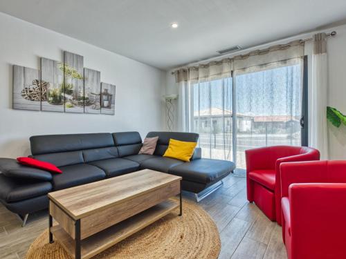 - un salon avec un canapé bleu et un fauteuil rouge dans l'établissement Villa Les Alyzés by Interhome, à Vensac