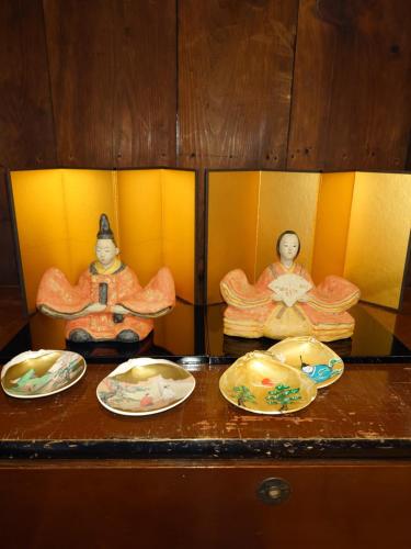 three statues sitting on a table with plates at ゲストハウス長閑 in Toyooka