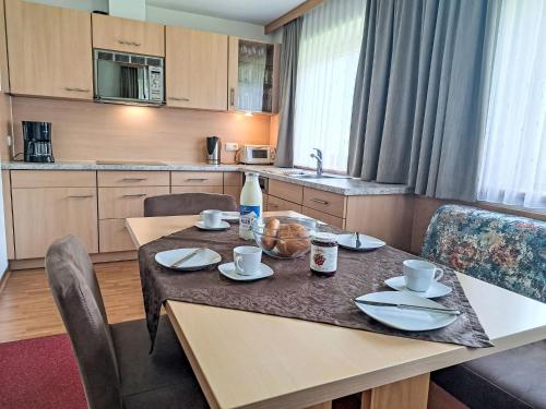 a kitchen with a table and chairs and a kitchen with a table and chairsktop at Apartment Rosa-2 by Interhome in Mayrhofen