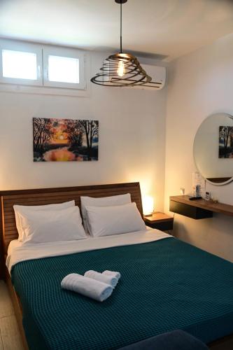 a bedroom with a bed with two towels on it at BIG BLUE HOTEL in Amaliápoli