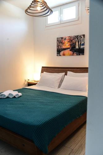 a bedroom with a bed with a green comforter at BIG BLUE HOTEL in Amaliápoli
