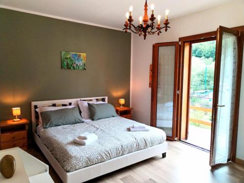 a bedroom with a bed and a sliding glass door at Green Riviera Case Vacanza in Borzonasca