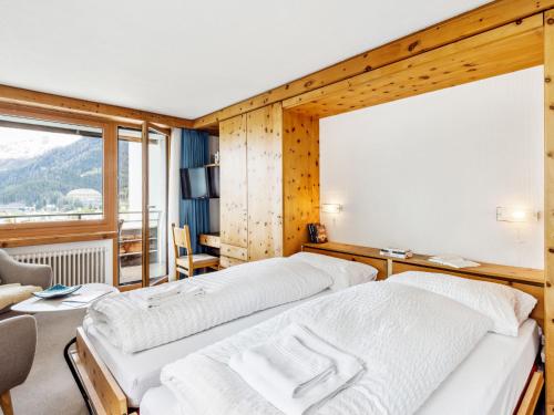 two beds in a room with a large window at Apartment Guardaval - Utoring-5 by Interhome in Davos