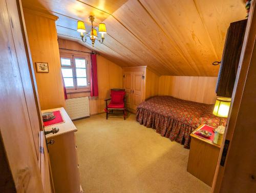 a bedroom with a bed and a chair in a room at Chalet Traumhaus in Arosa