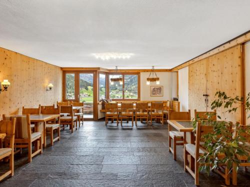 a restaurant with wooden tables and chairs and windows at Apartment Guardaval - Utoring-5 by Interhome in Davos