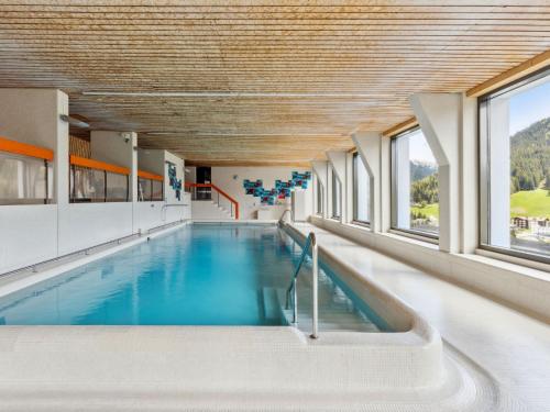 a swimming pool in a building with windows at Apartment Guardaval - Utoring-5 by Interhome in Davos