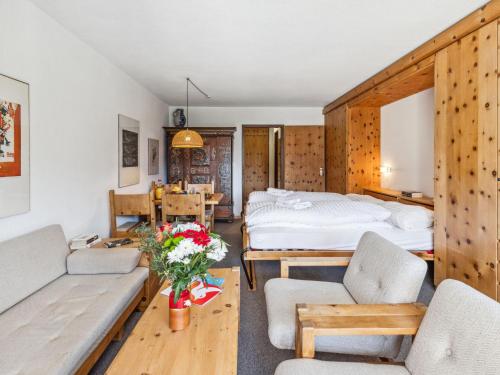 a bedroom with a bed and a living room at Apartment Guardaval - Utoring-9 by Interhome in Davos