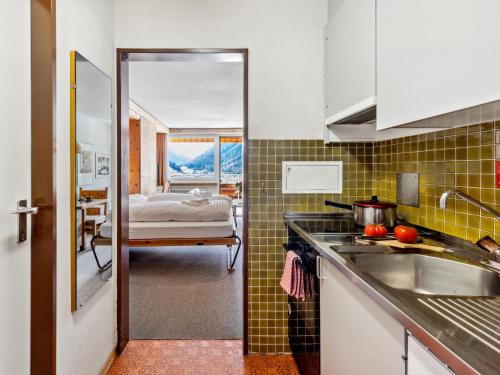a kitchen with a sink and a room with a bed at Apartment Guardaval - Utoring-9 by Interhome in Davos