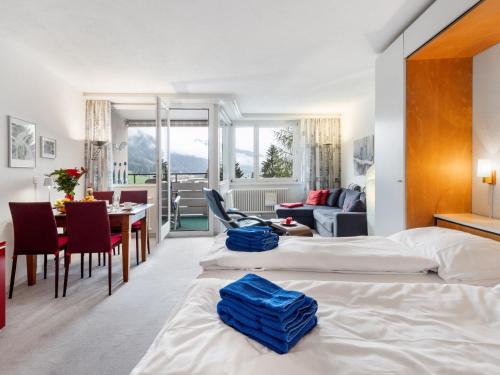a hotel room with two beds and a dining room at Apartment Parkareal - Utoring-13 by Interhome in Davos
