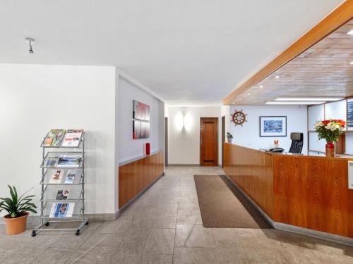 an office lobby with a desk and a hallway at Apartment Parkareal - Utoring-13 by Interhome in Davos