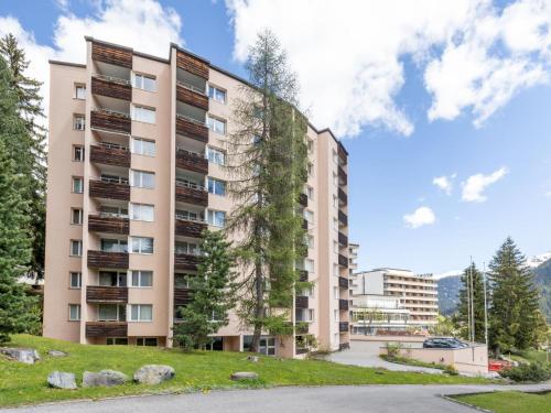 an apartment building with a tree on the side of it at Apartment Parkareal - Utoring-13 by Interhome in Davos