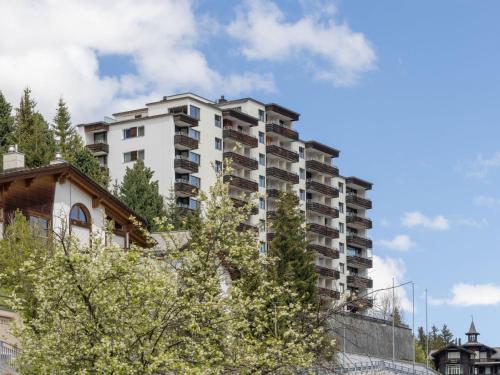 a tall white building with trees in front of it at Apartment Guardaval Apt 202 by Interhome in Davos