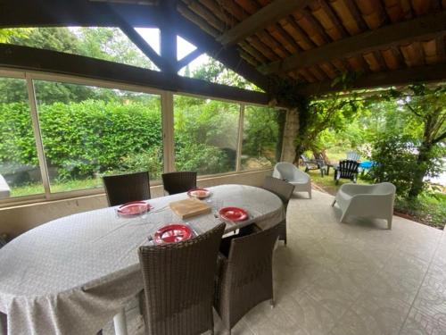 une salle à manger avec une table et des chaises sur un patio dans l'établissement Maison de vacances avec piscine à Grignan-Drôme provençale, à Grignan